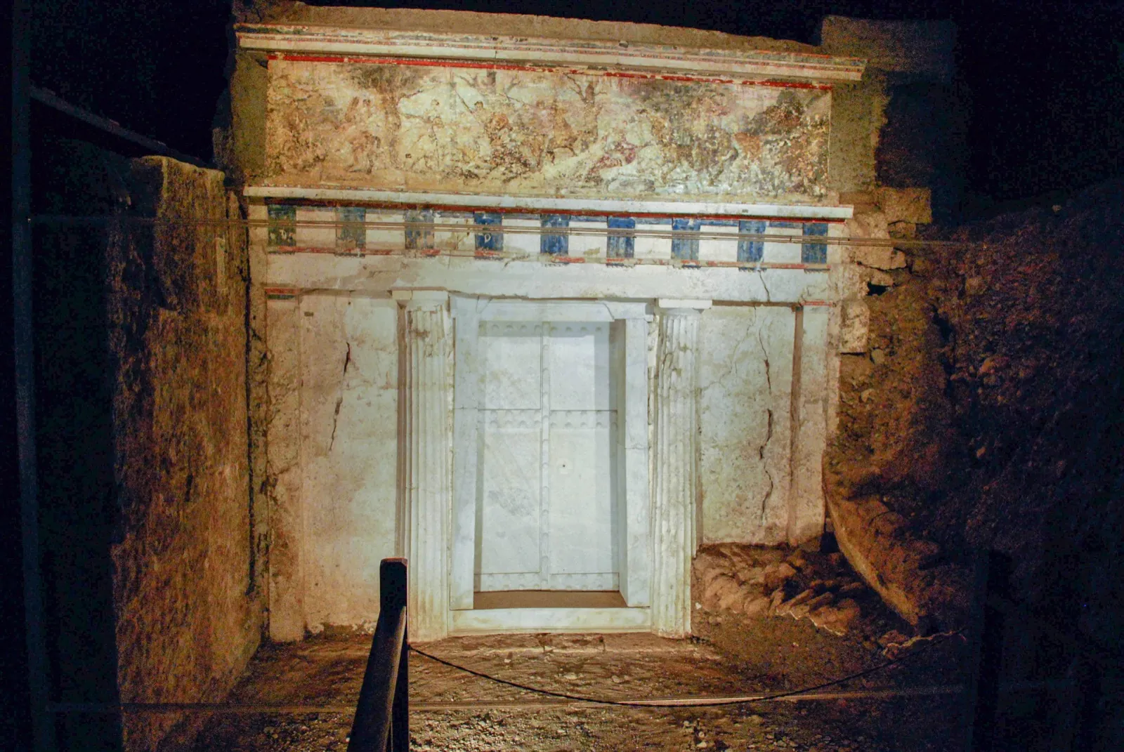 The painted marble façade and sealed doors of Tomb II, deep beneath the Great Tumulus at Vergina.